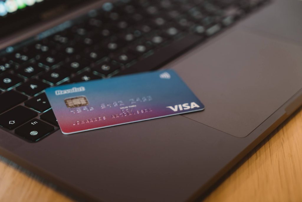 Une carte de crédit posée sur un ordinateur pour régler ses dettes rapidement