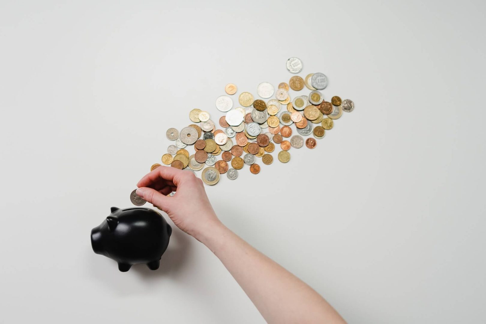 Someone putting coins in a piggy bank to illustrate payday loans in Niagara Falls
